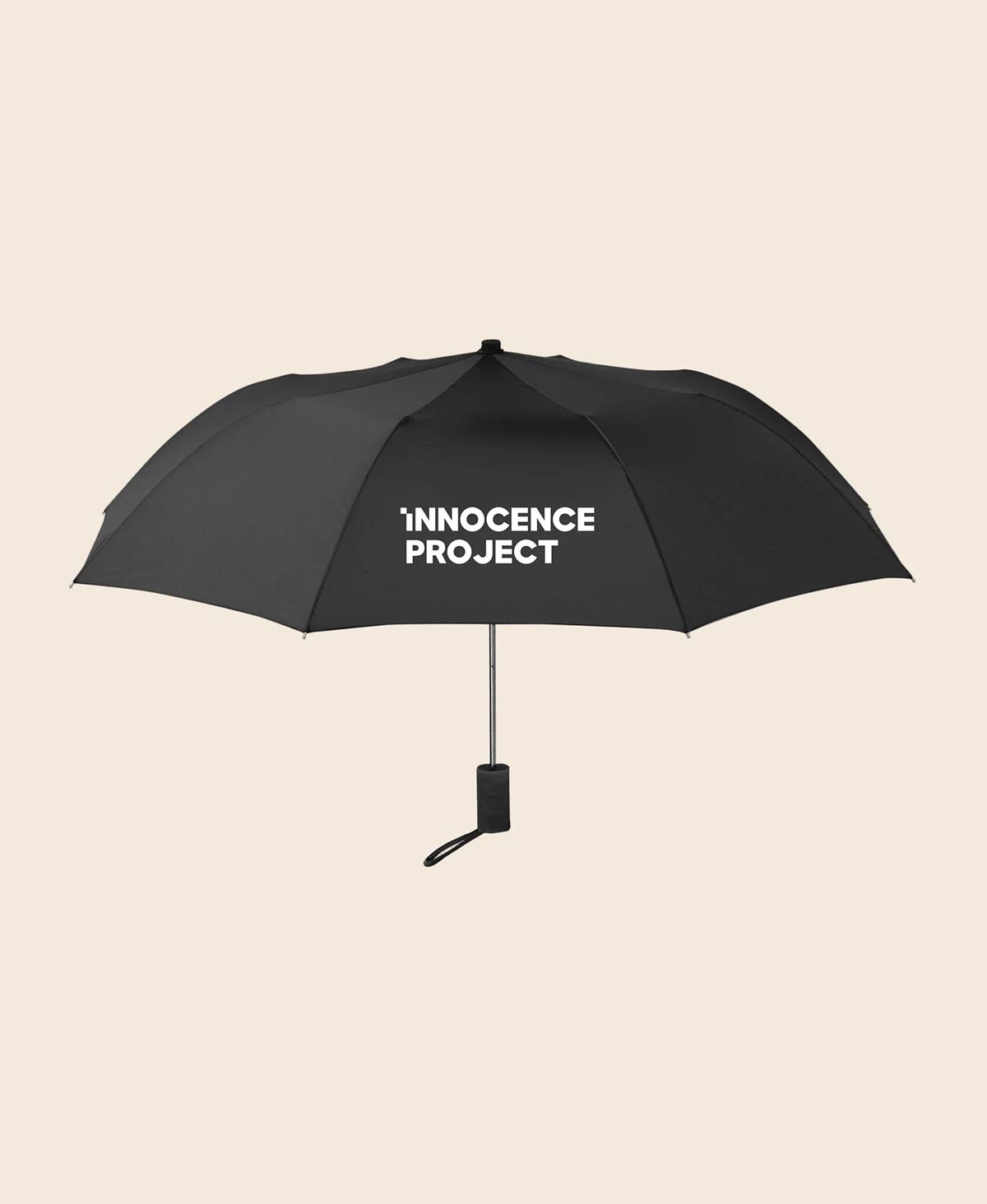 Black umbrella with 'Innocence Project' text on a beige background