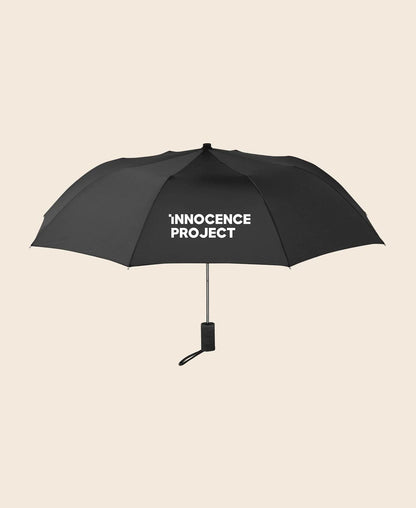 Black umbrella with 'Innocence Project' text on a beige background